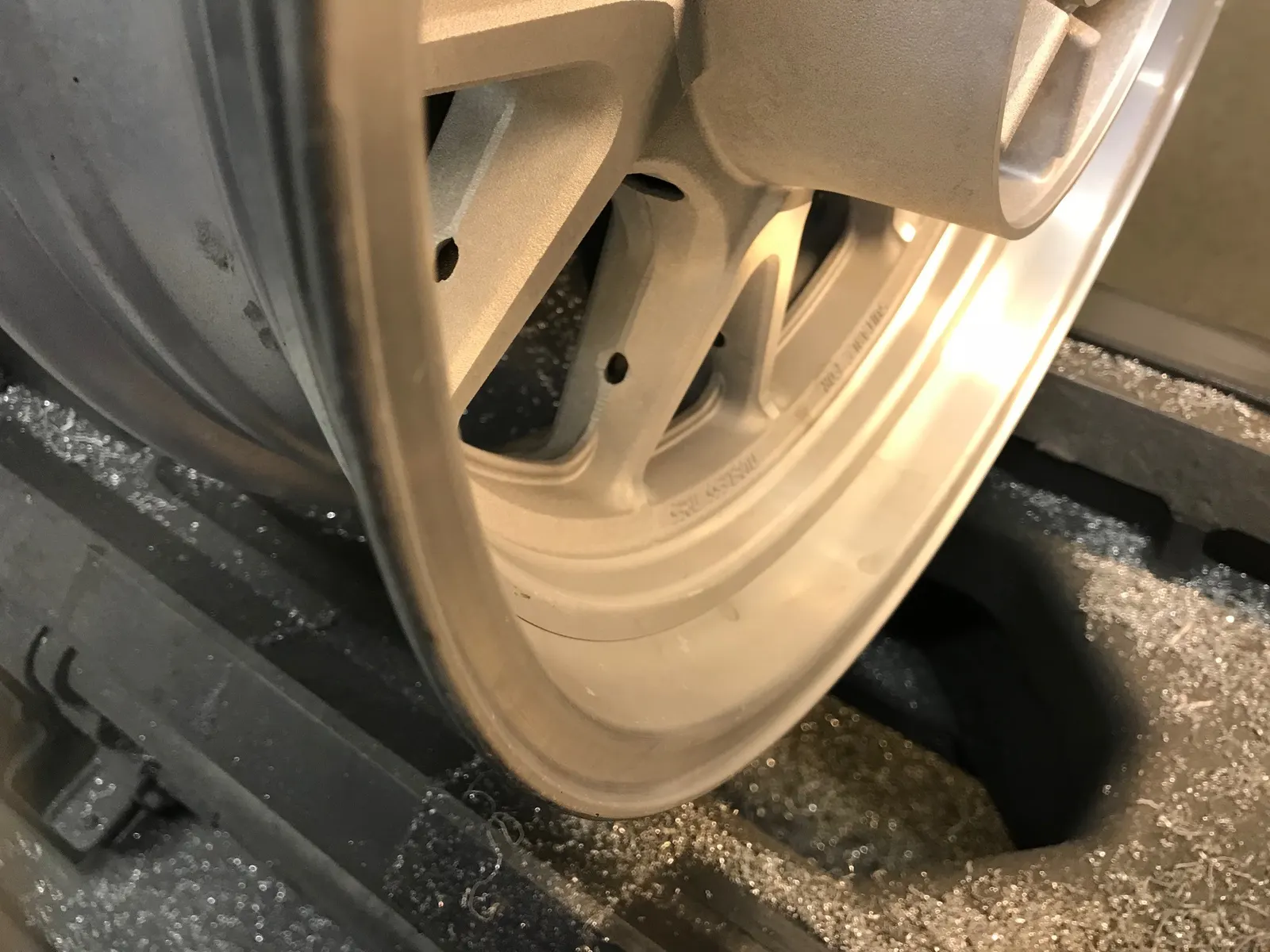 MC-fälg i rent aluminium efter kemisk avlackering, uppspänd i maskin